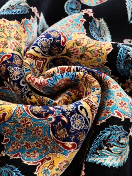 Jewel Medallion Rug in Black, machine-woven herbal-silk rug — rug softly draped and folded to show its silk-like sheen and drape