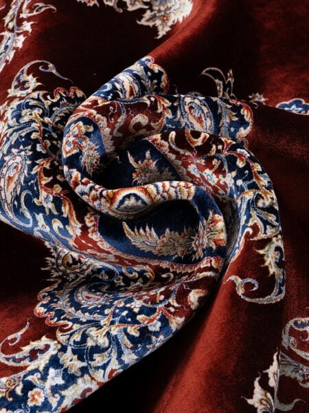 Regal Medallion Rug in Red, machine-woven herbal-silk rug — rug softly draped and folded to show its silk-like sheen and drape
