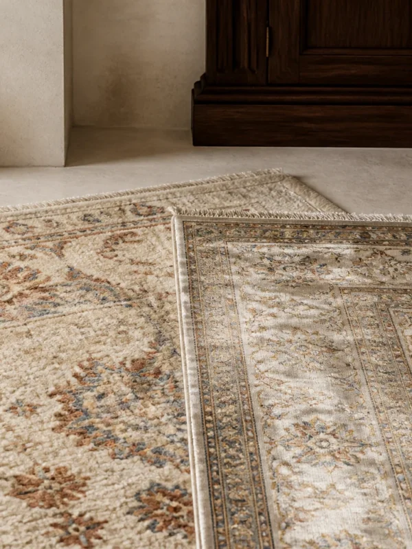 Two overlapping hand-knotted rugs showing the matte pile of wool beside the lustrous surface of silk